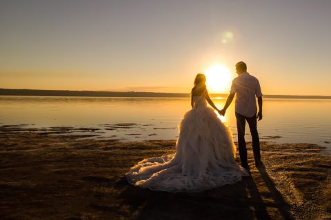 wedding couple on the sea beach watching sunset. sunny summer ph